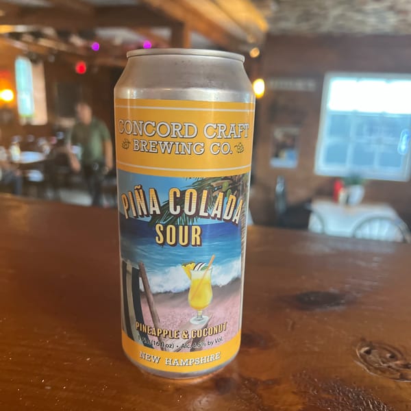 Concord Craft Brewing Co. Piña Colada Sour beer can on a wooden bar at Riley's Place.
